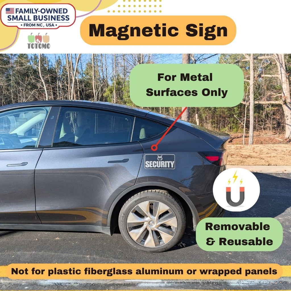 Car with a magnetic sign attached, outdoors with trees in the background