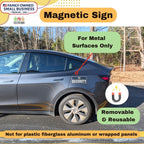 Car with a magnetic sign attached, outdoors with trees in the background