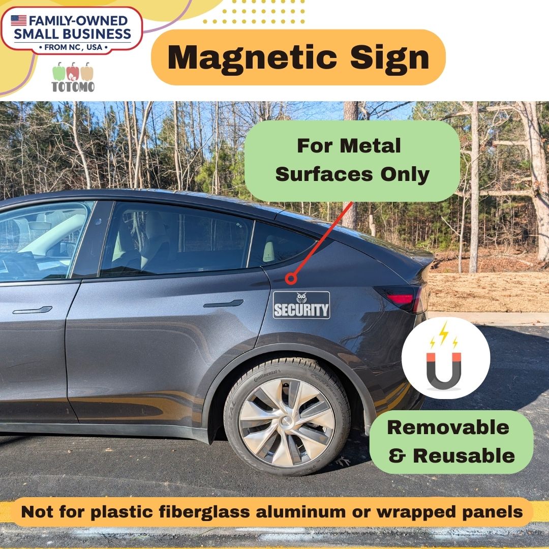 Car with a magnetic sign attached, outdoors with trees in the background