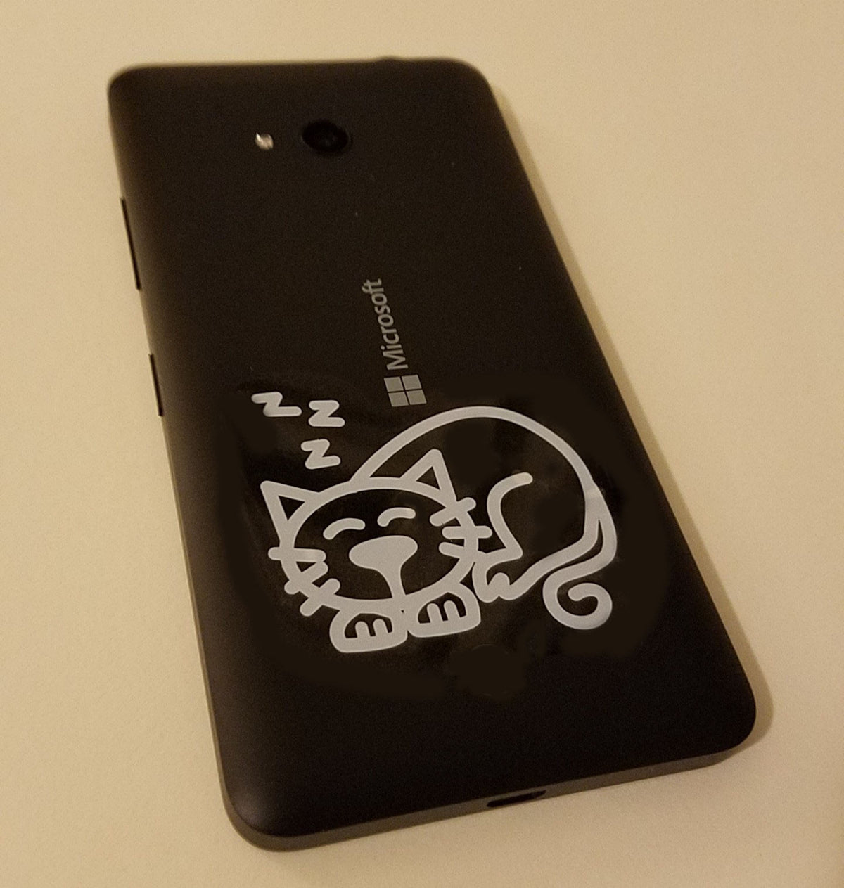 TOTOMO sleeping cat decal applied to the back of a phone